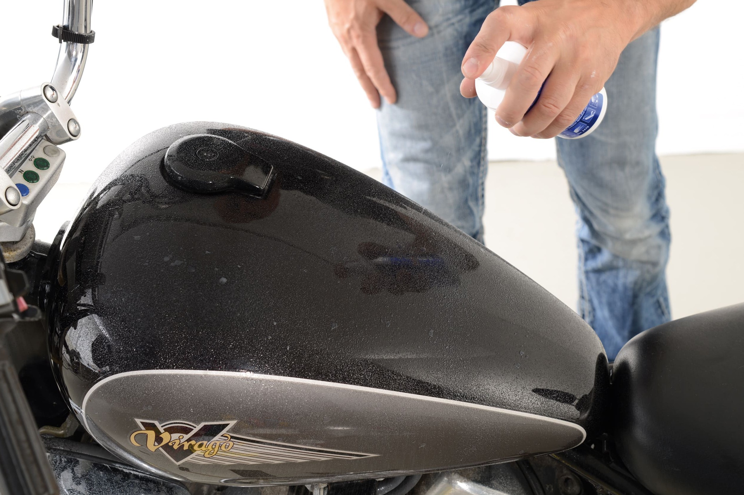 Application contrôlée d’un produit sur le carénage rouge d’une moto